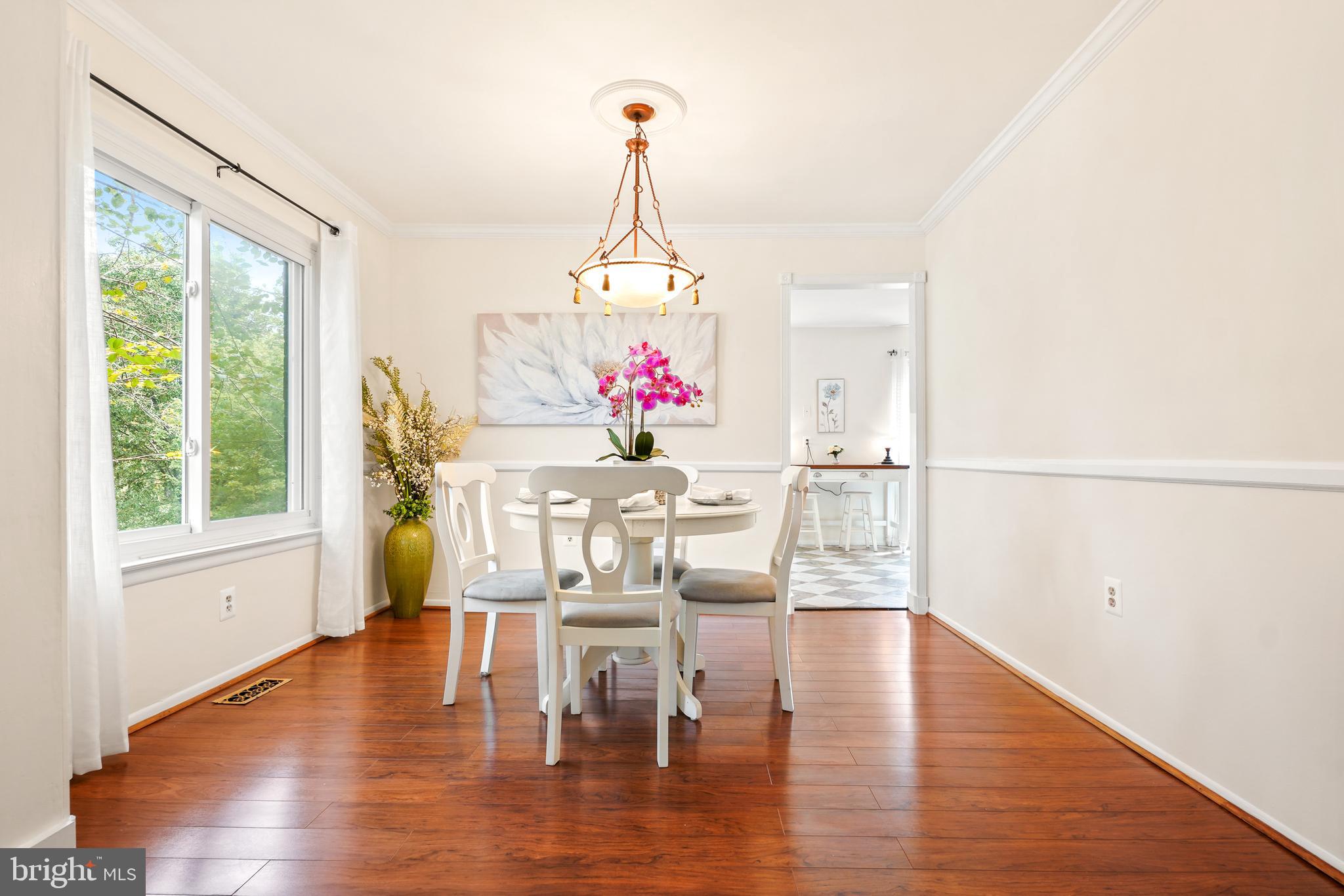 8900 Centerway Road Gaithersburg, MD 20879 - Photo 5 of 32 a dining room with wooden floor a chandelier a glass table and chairs