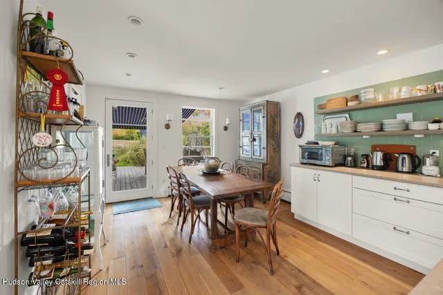 a kitchen with stainless steel appliances granite countertop a stove top oven a dining table and chairs with wooden floor