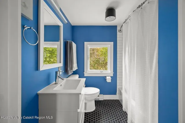 a bathroom with a sink a toilet and a window