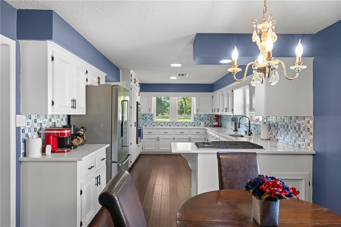 871 Cazey Loop Franklin, TX 77856 - Photo 14 of 42 a kitchen with refrigerator a sink dishwasher a dining table and chairs with wooden floor