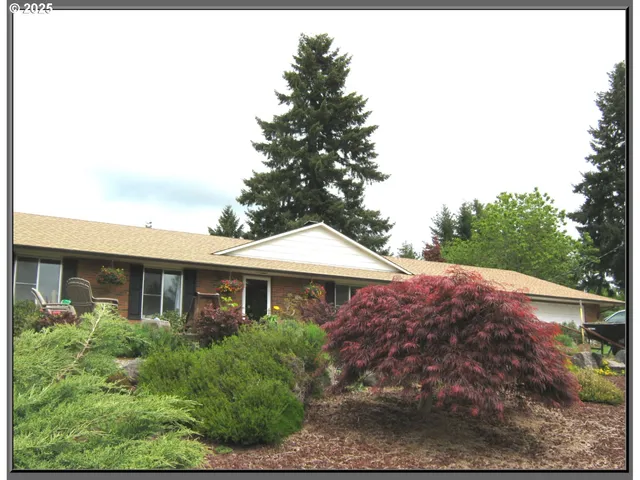 a front view of house with yard and trees around