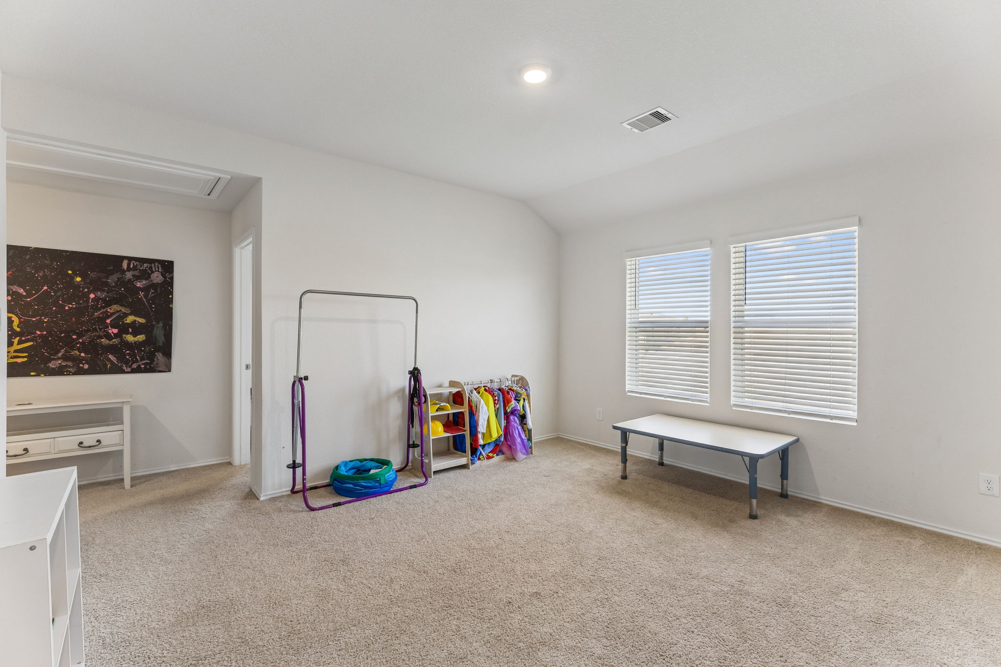 343 Sickle Loop Kyle, TX 78640 - Photo 19 of 40 Carpeted room with bright white walls, featuring two large windows with horizontal blinds, recessed lighting, and a visible air vent for climate control