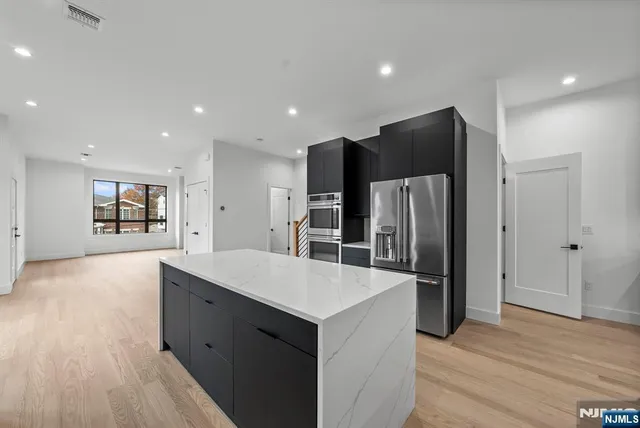 a view of an empty room with a cabinet and a window
