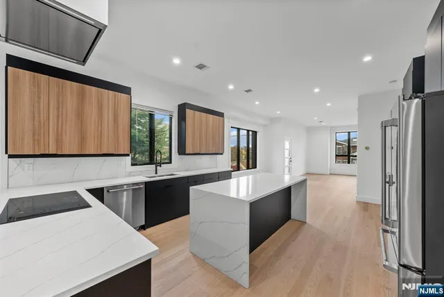 a kitchen with stainless steel appliances wooden cabinets and a refrigerator