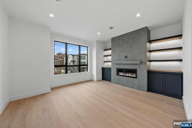 a view of an empty room with a fireplace and a window