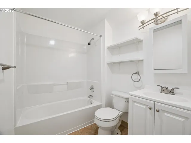 a bathroom with a sink toilet vanity and shower