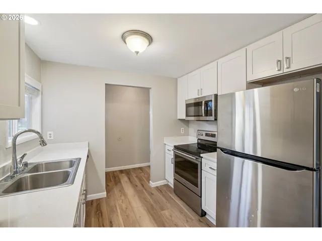 a kitchen with granite countertop a refrigerator stove and sink