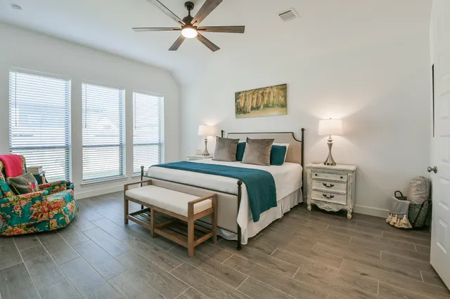 a bedroom with a bed and a flat tv screen on the dresser