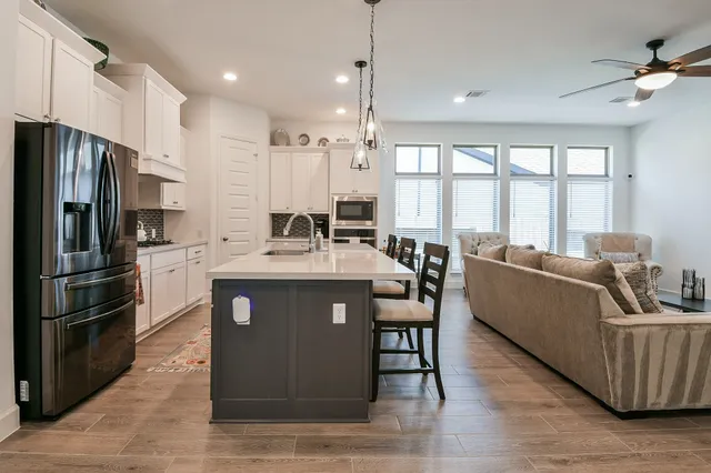 a kitchen with stainless steel appliances granite countertop a sink a stove and a refrigerator
