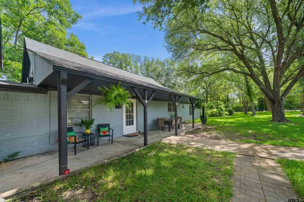 a view of a patio with table and chairs under an umbrella