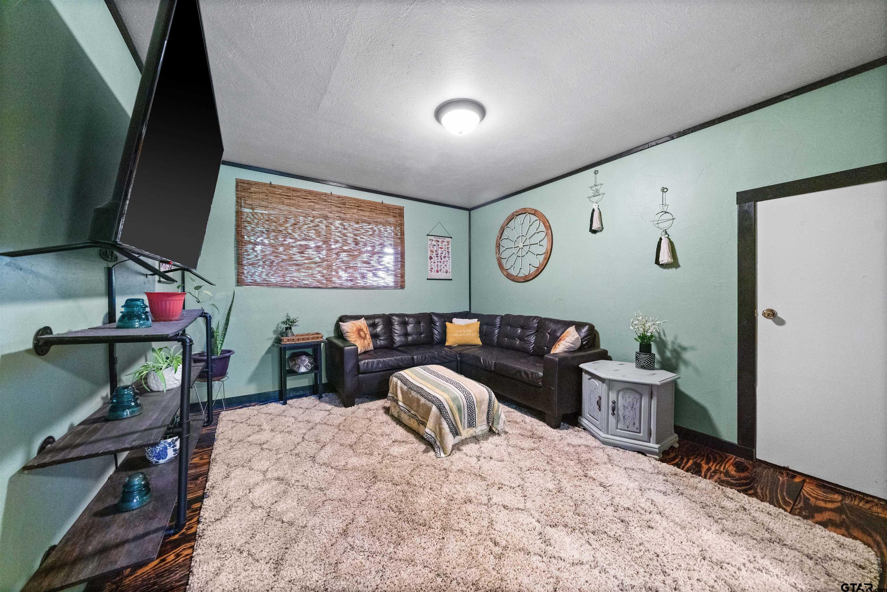 110 Utah Street Van, TX 75790 - Photo 13 of 48 a bedroom with a bed and a bookshelf with wooden floor