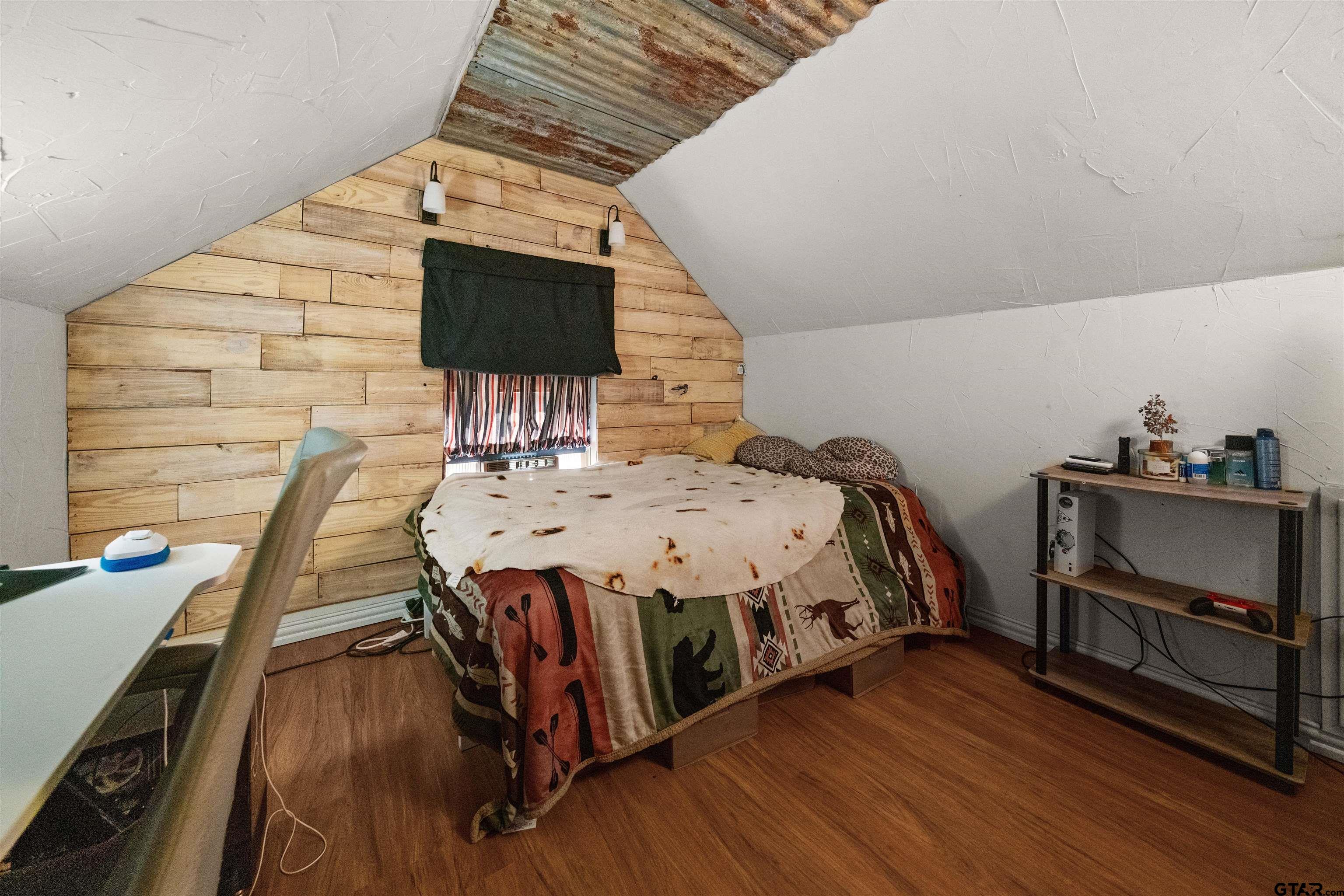 110 Utah Street Van, TX 75790 - Photo 23 of 48 a bed sitting in a bedroom next to a window with wooden floor