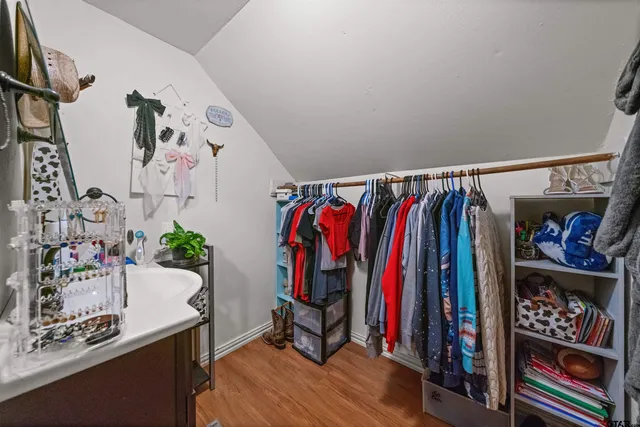 a view of walk in closet with clothes and shoes