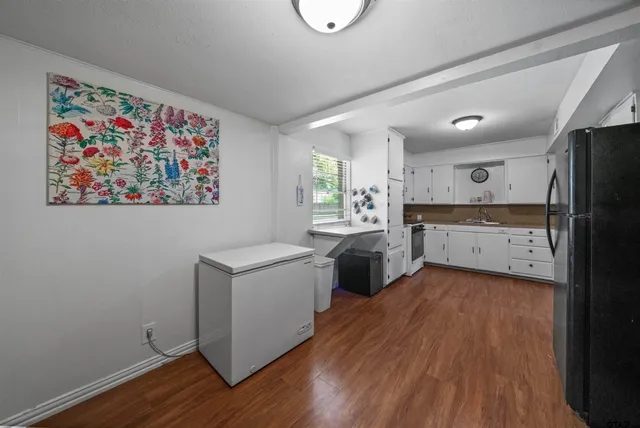 a view of kitchen with stainless steel appliances cabinets and wooden floor