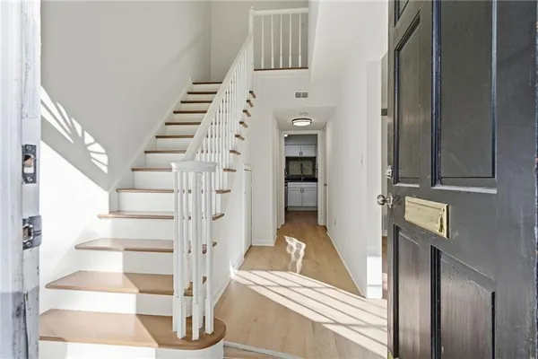 a view of entryway and hall with wooden floor