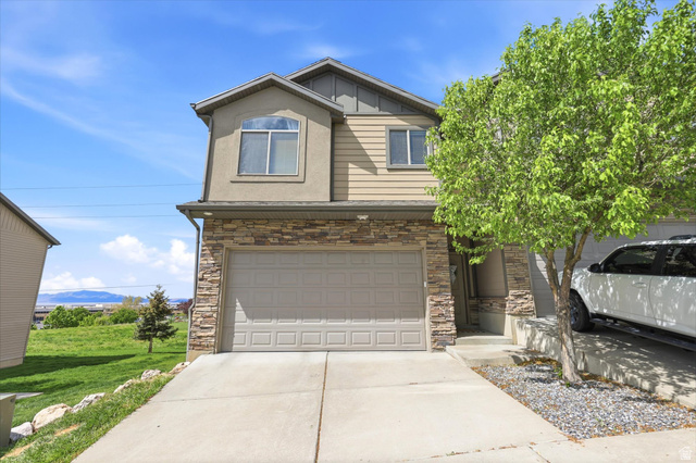 2949 North 1175th Street West Layton, UT 84041 - Photo 1 of 1 View of front of house featuring stone siding, board and batten siding, concrete driveway, a garage, and a mountain view