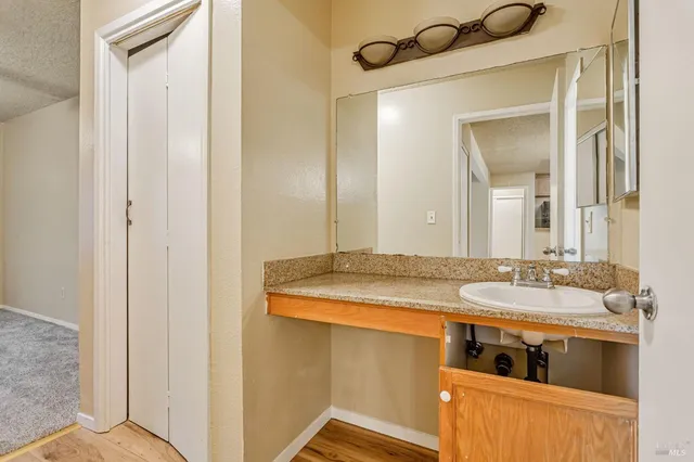 a bathroom with a granite countertop sink and a mirror