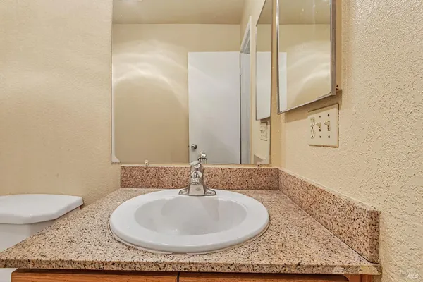 a bathroom with a granite countertop sink and a mirror