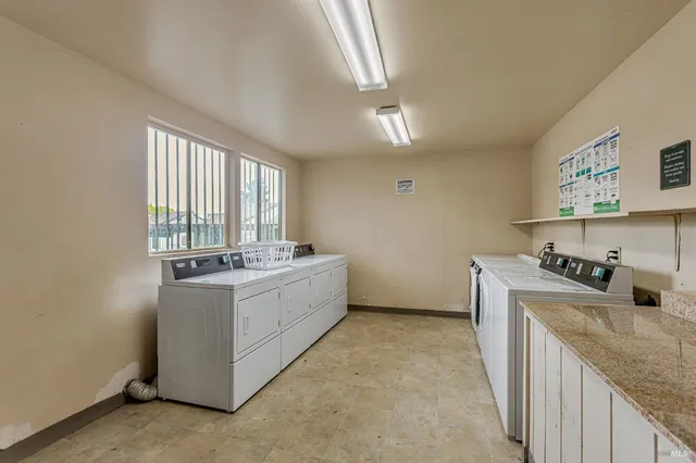 a large white kitchen with stainless steel appliances granite countertop a sink and cabinets