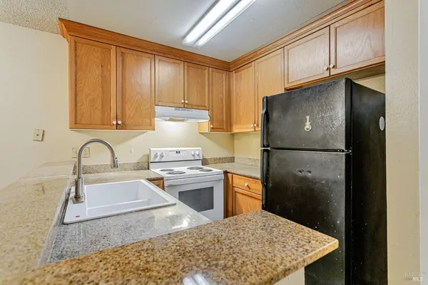 a kitchen with stainless steel appliances granite countertop a refrigerator sink and cabinets