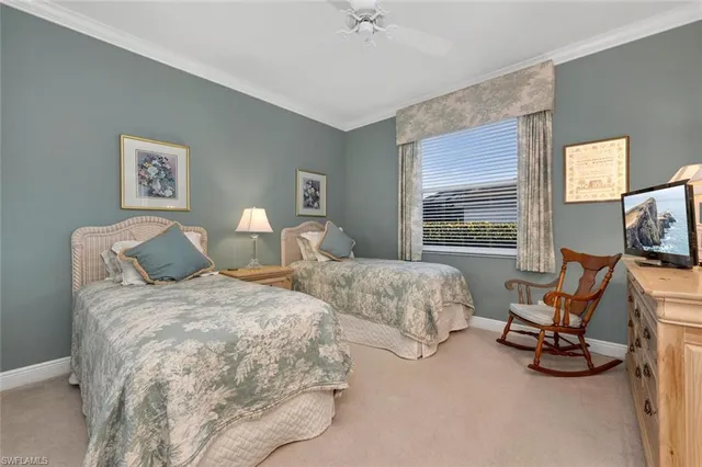 a bedroom with two beds and a large mirror next to a window