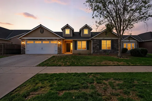 a front view of a house with a garden and yard
