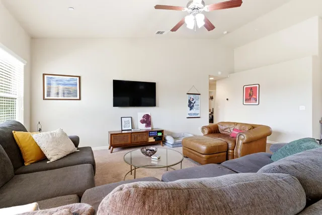 a living room with granite countertop furniture a fireplace kitchen view and a large window