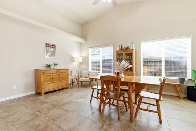 a kitchen with a dining table chairs and large window