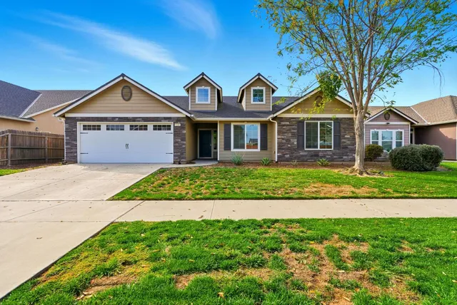 a front view of a house with a garden and plants