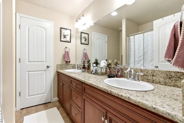 a bathroom with a granite countertop sink and a mirror