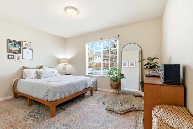 a bedroom with a bed and a painting on the wall