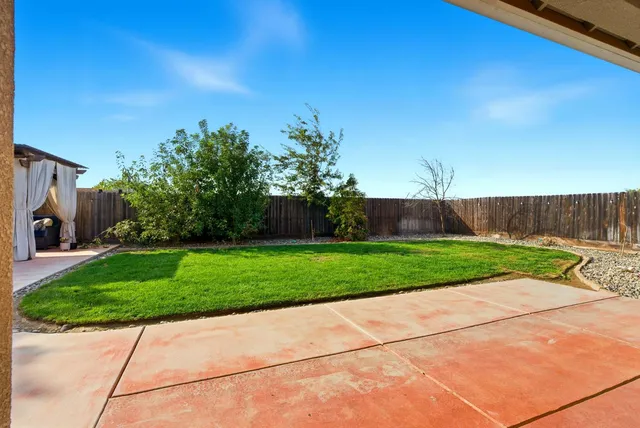 a view of backyard with swimming pool and seating space