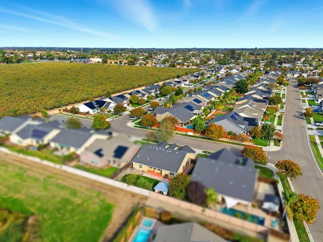 an aerial view of a house with garden space and a car parked