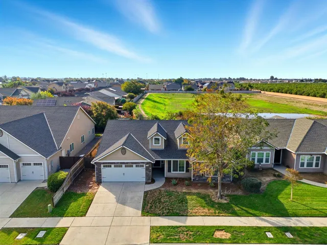 an aerial view of a house with a garden and lake view