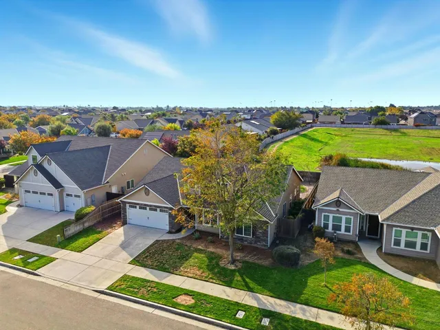 an aerial view of residential houses with yard and ocean view