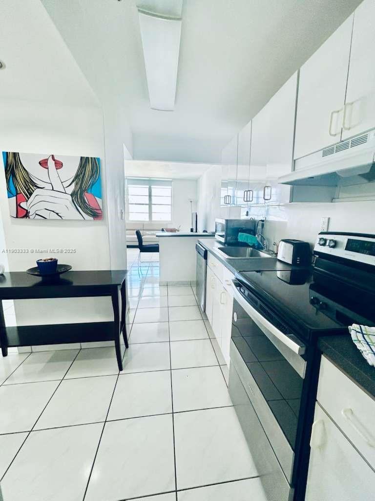 100 Lincoln Road, Unit 1639 Miami Beach, FL 33139 - Photo 6 of 10 a kitchen with stainless steel appliances cabinets a sink and a counter top space