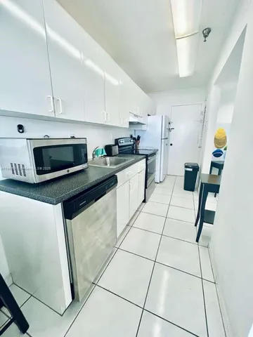 a kitchen with stainless steel appliances granite countertop a stove a sink a counter top space and cabinets