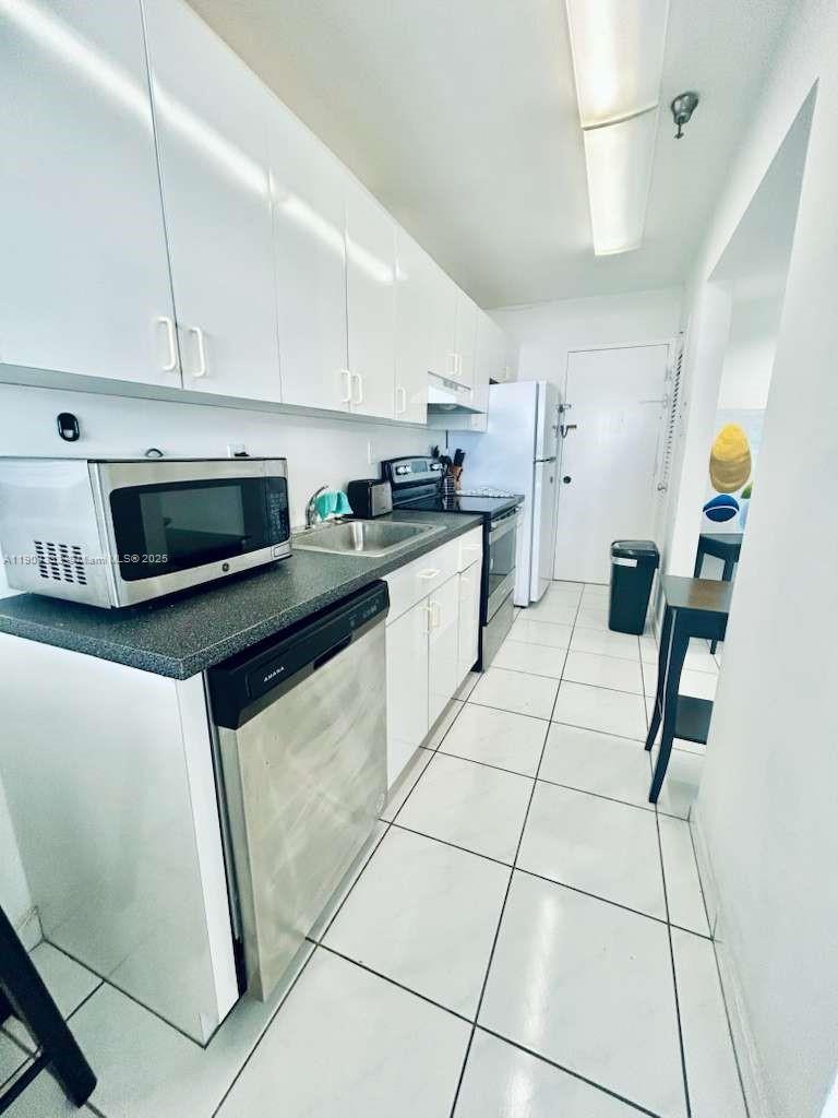100 Lincoln Road, Unit 1639 Miami Beach, FL 33139 - Photo 7 of 10 a kitchen with stainless steel appliances granite countertop a stove a sink a counter top space and cabinets