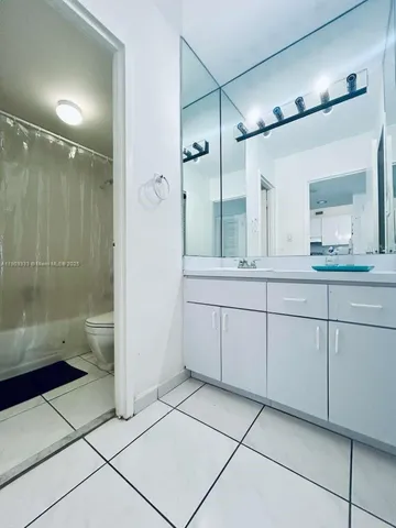 a bathroom with a double vanity sink toilet and shower