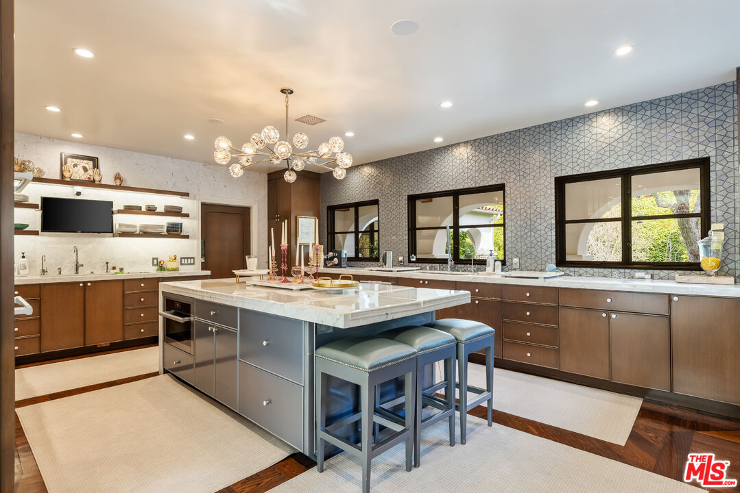 1109 Tower Road Beverly Hills, CA 90210 - Photo 12 of 32 a kitchen with stainless steel appliances granite countertop a stove top oven a sink dishwasher and a refrigerator