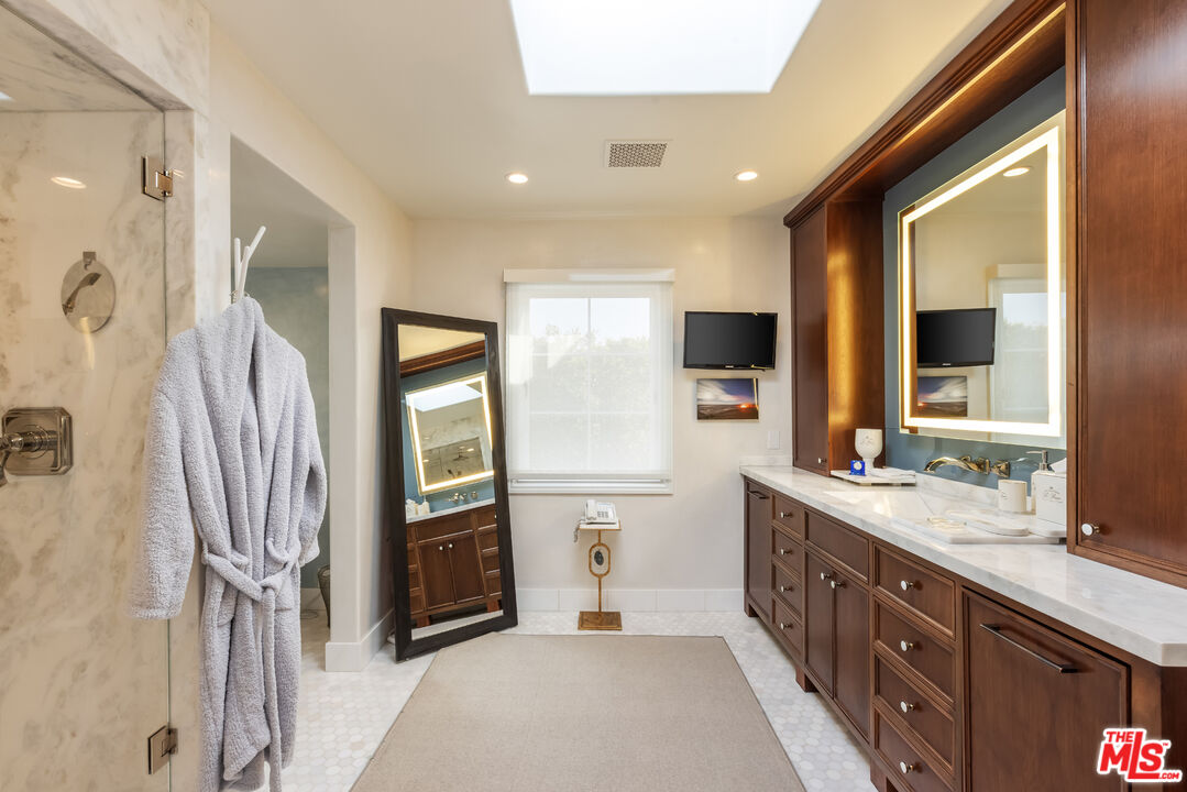 1109 Tower Road Beverly Hills, CA 90210 - Photo 25 of 32 a spacious bathroom with a double vanity sink and a mirror