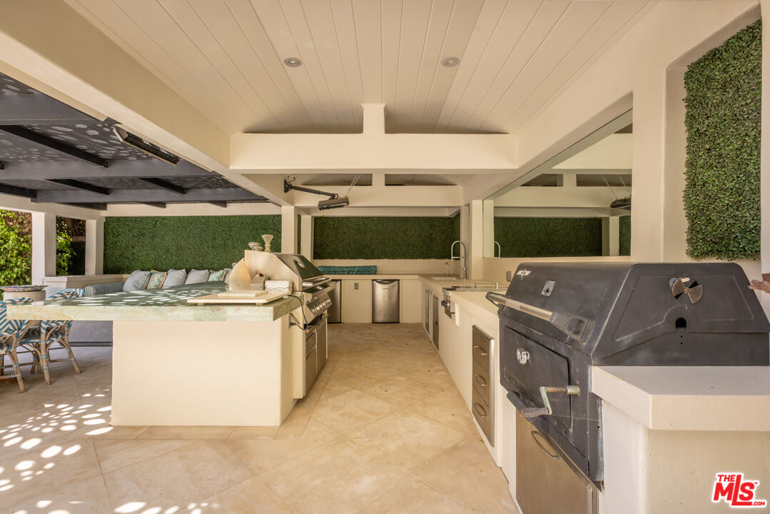 1109 Tower Road Beverly Hills, CA 90210 - Photo 28 of 32 a kitchen with stainless steel appliances kitchen island granite countertop a stove and a microwave oven
