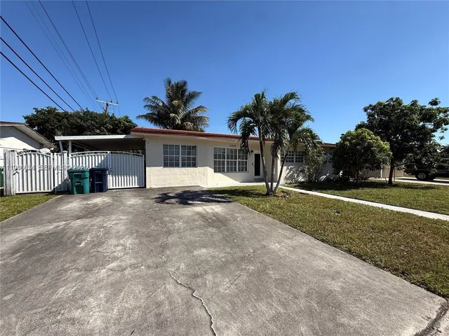 a view of a house with backyard and a tree