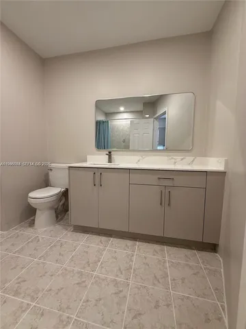 a bathroom with a sink a toilet and mirror