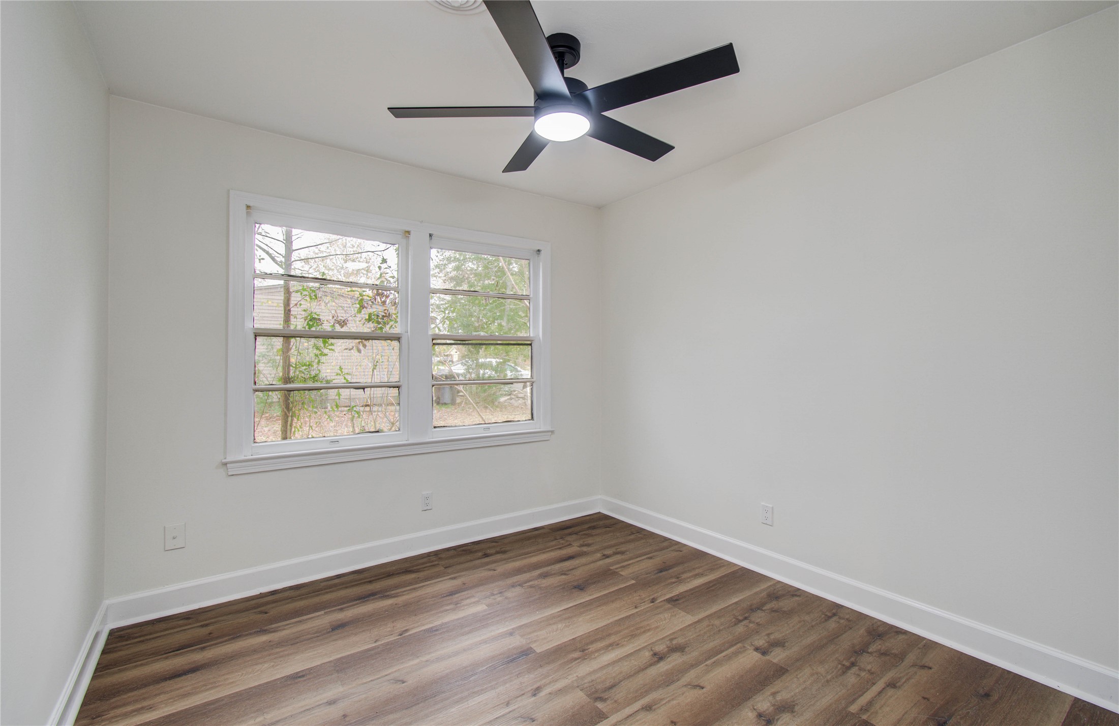 2417 Pecan Street Dickinson, TX 77539 - Photo 34 of 43 an empty room with wooden floor ceiling fan and windows