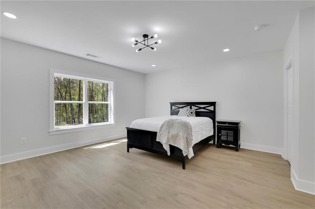 1610 Double Springs Church Road Monroe, GA 30656 - Photo 60 of 81 a spacious bedroom with a bed and a chandelier