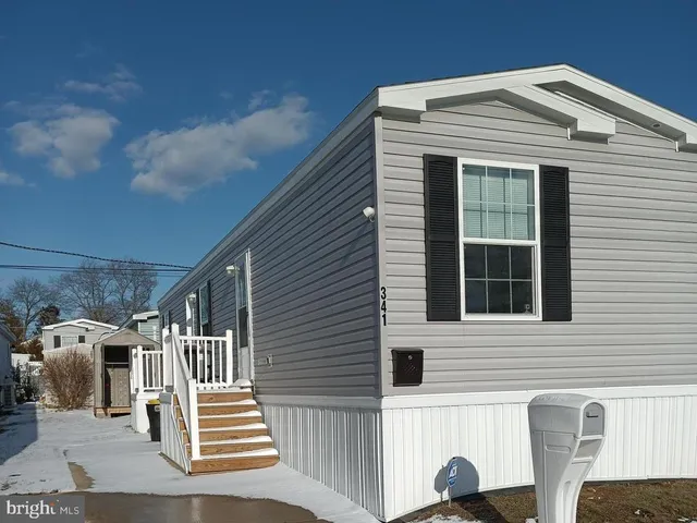a front view of a house with stairs and a white fence