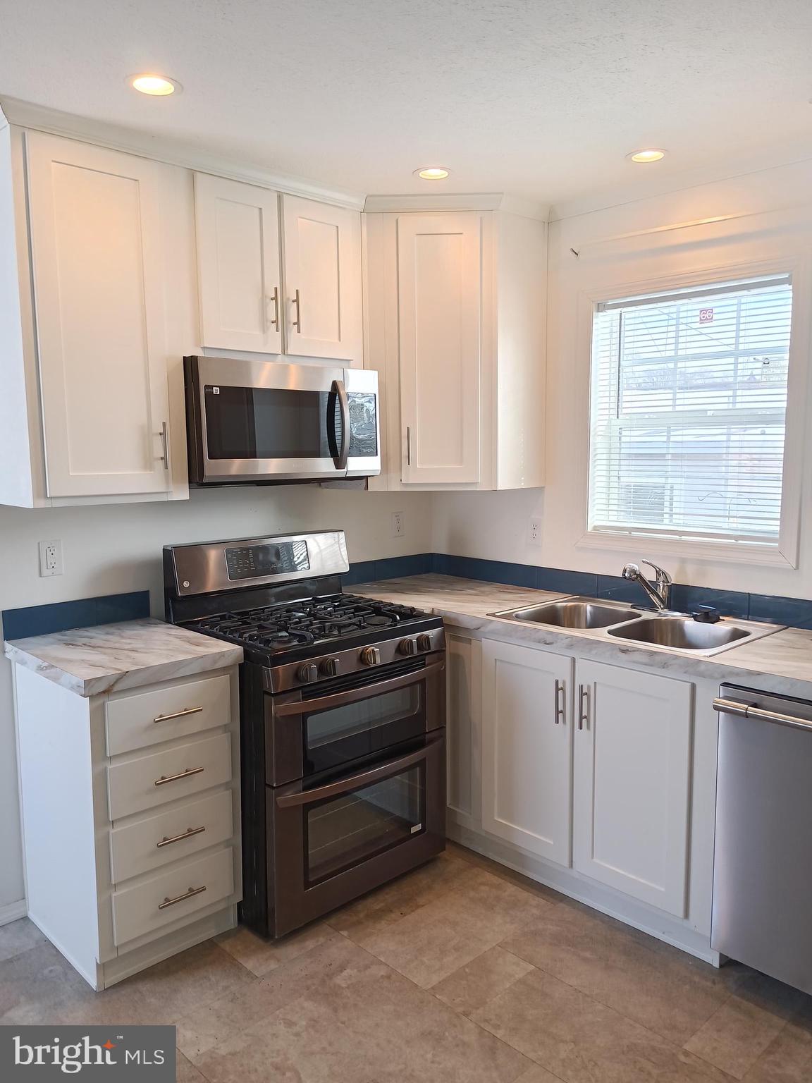1405 Farrell Avenue, Unit 341 Cherry Hill, NJ 08002 - Photo 4 of 20 a kitchen with stainless steel appliances granite countertop a stove microwave and sink