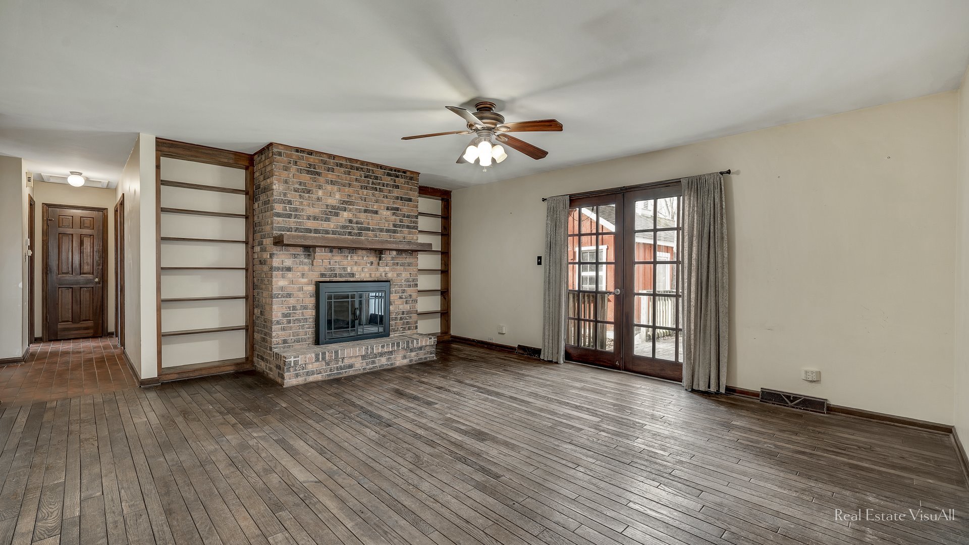 5-n994 Corron Road St. Charles, IL 60175 - Photo 13 of 39 an empty room with wooden floor a ceiling fan a fireplace and windows