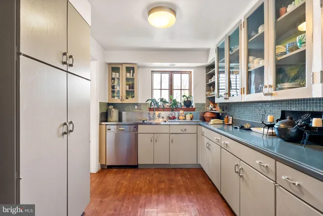 a kitchen with a sink cabinets stainless steel appliances and windows